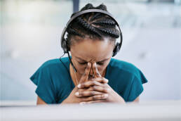 Black woman feeling overwhelmed holding her head in her hands